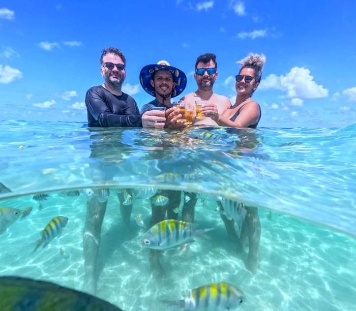 Amigos brindando nas Piscinas Naturais do Seixas durante passeio de barco em João Pessoa