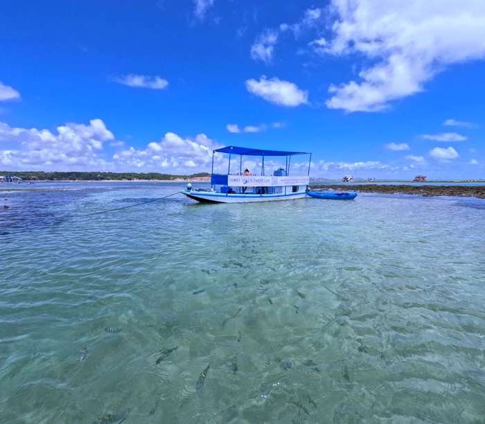 Barco ancorado na maré baixa nas Piscinas Naturais do Seixas, João Pessoa